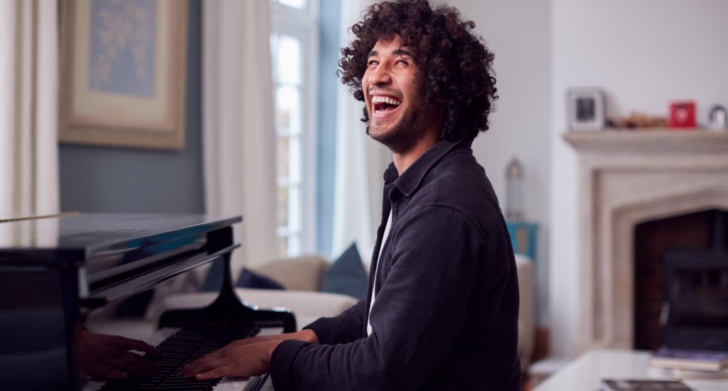 young-man-sitting-at-grand-piano-and-playing-at-ho-2021-08-30-06-14-52-utc-1.jpg